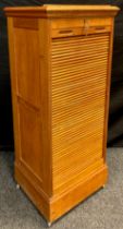 A golden oak music cabinet, tambour front enclosing eight music sheet drawers, lift-up ‘lectern’