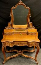 A Baroque Louis XV style carved walnut dressing table, shaped mirror with carved cresting and