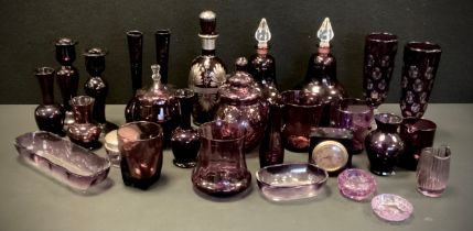 A quantity of amethyst glass including; a pair of candlesticks, 20cm high, jars with stoppers, a