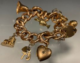 A 9ct gold fancy link charm bracelet, suspending seven gold and gold plated charms, 9ct gold padlock