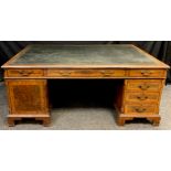 A George III style mahogany and walnut veneered partner’s desk, dark green faux leather writing