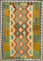 A Turkish Anatolian Kilim, knotted with a geometric pattern in tones of red, blue, green, and cream,