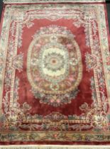 An impressive Chinese deep-pile wool carpet, in subdued tones of red, green, pink, and cream,