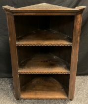 An early to mid 20th century oak wall-mounted corner shelving unit, three tiers of open shelving,