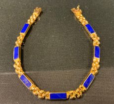 A lapis lazuli mounted yellow metal fancy link bracelet, indistinct marks possibly Egyptian, 14.2g