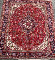 A North West Persian Heriz carpet, hand-knotted with a central diamond-form medallion, within a