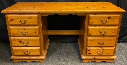 A pine pedestal desk, four short drawers to each pedestal, brass swan-neck handles, 78.5cm high x
