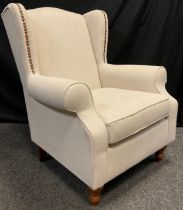 A contemporary wing-back armchair, 100.5cm high x 83.5cm wide.