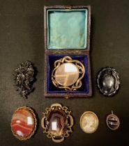 A Victorian hairwork mourning brooch, yellow metal mount, others banded agate, carved Whitby jet,