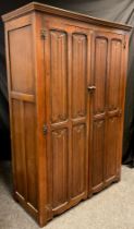 A mid 20th century Goodall's of Manchester oak double wardrobe, moulded cornice above a pair of