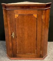 A George III oak corner cupboard, wall-mounted, canted front, inlay to door, enclosing two tiers