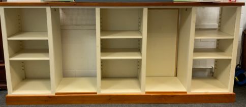 A shop fitting display unit, pine top and plinth, with five shelf or hanging rail compartments, hook