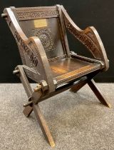 A Victorian oak Canterbury chair, Gothic revival carving, X-frame legs, octagonal stretcher, 85.