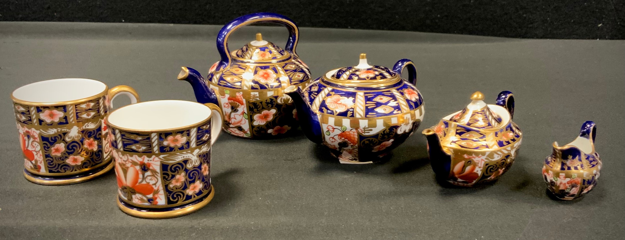 Royal Crown Derby - a miniature 6299 pattern three piece tea set, larger teapot, oval teapot, milk