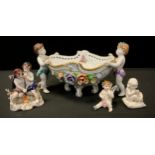 A Continental, Dresden style, boat shaped bowl, as two cherub figures hold the bowl, embossed with