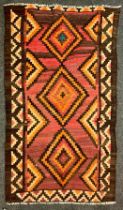 A Qashgai Kilim rug, in tones of oranges, browns and pink 210cm x 115cm.