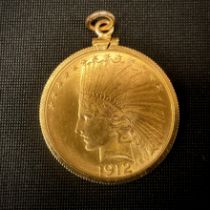 Coins & Tokens - a United States of America ten Dollar gold coloured metal coin, Indian Head beneath