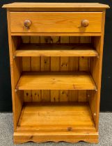 A pine bookcase, single long drawer to frieze, three tiers of shelving, 101.5cm high x 66cm wide x