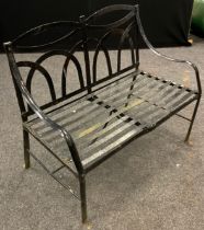 An early to mid 20th century iron strapwork garden bench, arched back, slat strap seat, painted