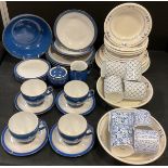 A Denby dark blue table service for four comprising for tea cups and saucers, four large dinner