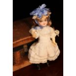 A late 19th century French bisque head Bébé doll, of small proportions, the bisque head with inset