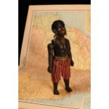 An early 20th century black composition jointed doll, painted features, black flock type hair,