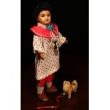 A French bisque head and painted composition black doll, the painted bisque head inset with fixed