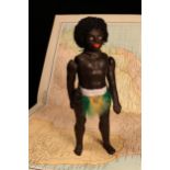 An early 20th century black composition jointed doll, painted features, black flock type hair,
