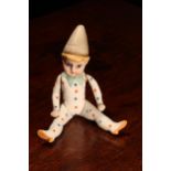 A novelty all-bisque jointed miniature doll, dressed as a performing Clown, the bisque head inset