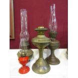 3 brass base oil lamps and a miniature red oil lamp