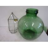 A green glass carboy and a glass wall planter