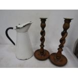 An enamel jug and a pair of treen candlesticks