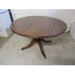 Round mahogany pedestal dining table with brass Lions paw feet and castors H77cm Top D123cm approx