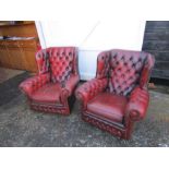 Pair of ox blood red leather button back wing armchairs (some damage to one chair as seen in