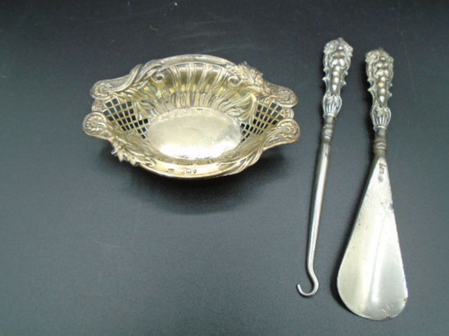 A silver hallmarked pin tray - London 1895 and a Silver handled button hook and shoe horn -