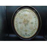 An oval framed and glazed stitchwork/sampler with date of 1802 stitched on the bottom. some damage