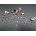 A collection of stick pins and a hat pin - to include a gloved hand pin