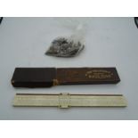 A boxed Keuffel & Esser co slide rule and a bag of various keys.