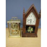 A wooden cased gothic and battery anniversary clock