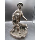 A patinated sculpture of a farmer with lambs and his dog