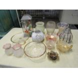 Glass vases, bowls, vintage lamp shades and flower arrangement in glass case