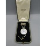 A fob watch with floral face and silver bow pin badge and key, in box