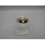 A 9ct gold ring set with opals and garnet 3.6gms