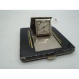 A metal art deco compact with built in pop up watch.