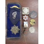 A silver masonic lapel, pin badges a medal and coin brooches