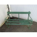 Antique wrought iron garden bench with wooden slats in need of repair