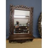 A wooden framed fret work wall mirror with pegs