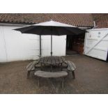 Round wooden Picnic table with benches and parasol