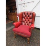 Ox blood red Chesterfield style Queen Anne wingback armchair with ball and claw feet