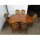 Extending dining table with 6 upholstered cane backed chairs